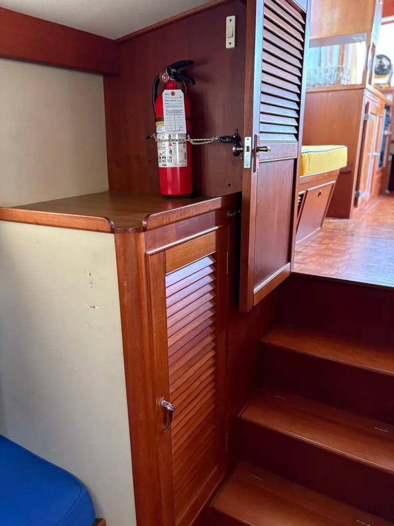 Slide: The Image of Interior of 1986 Grand Banks 36 Classic with wooden cabinetry and fire extinguisher. - 16