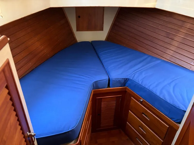 Slide: The Image of Interior cabin of 1986 Grand Banks 36 Classic with blue cushions and wooden cabinetry. - 18