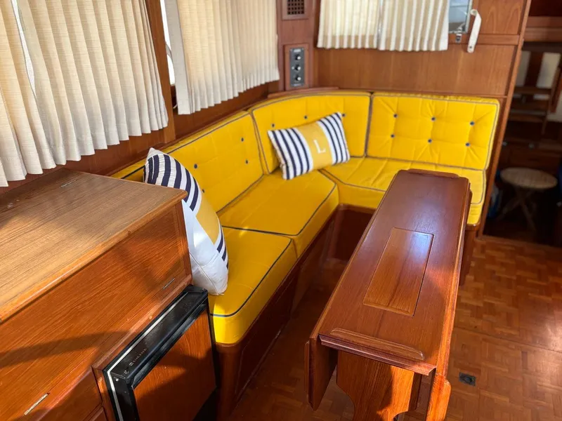 Slide: The Image of Interior of 1986 Grand Banks 36 Classic with yellow seating and wooden table. - 22