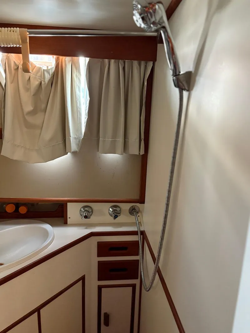 Slide: The Image of 1986 Grand Banks 36 Classic yacht bathroom with shower, sink, and curtains. - 24