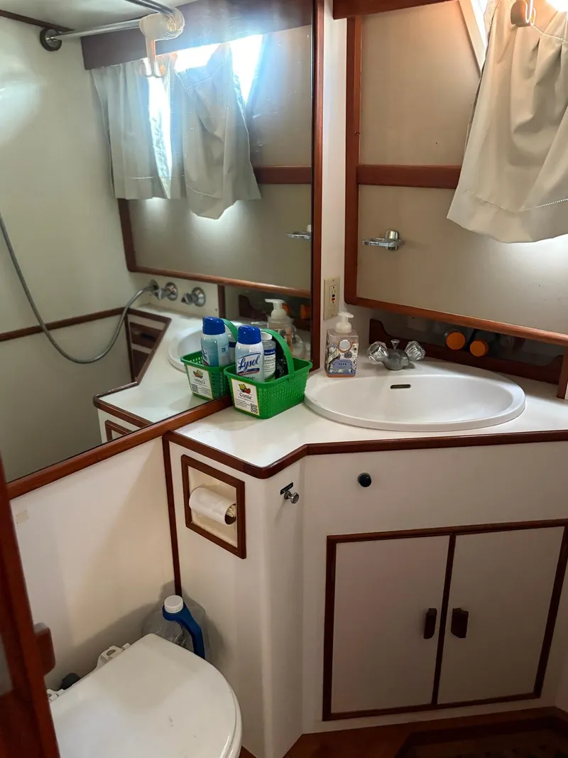 Slide: The Image of Bathroom interior of 1986 Grand Banks 36 Classic yacht, featuring sink and cleaning supplies. - 25