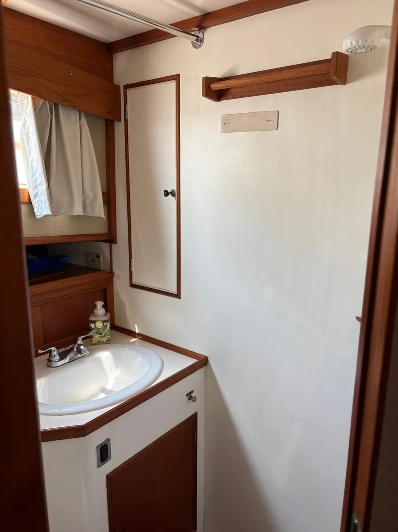 Slide: The Image of 1986 Grand Banks 36 Classic bathroom with sink, mirror, and wooden accents. - 26