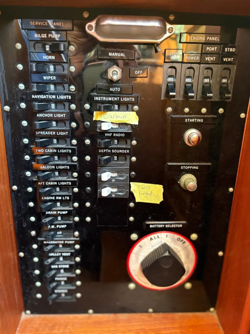 Slide: The Image of Control panel of a 1986 Grand Banks 36 Classic boat with labeled switches and dials. - 28