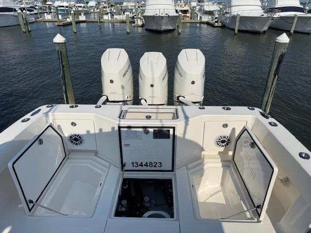 Slide: The Image of 2024 SeaVee Open Fisherman 390Z with triple outboard engines docked at a marina. - 11