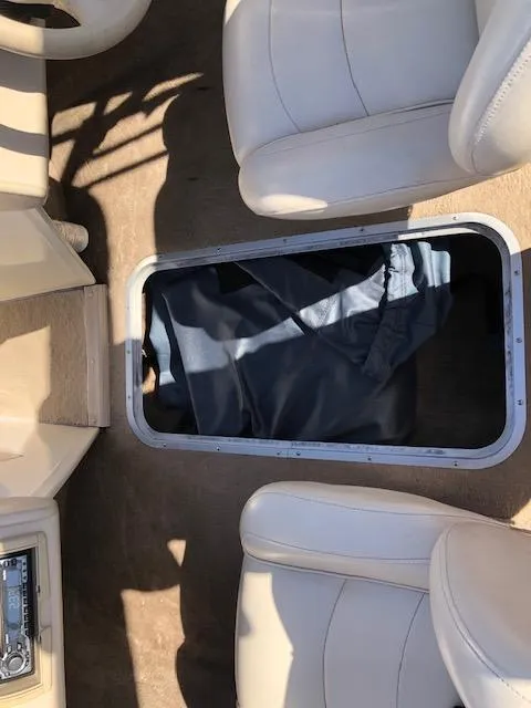 Slide: The Image of 2001 Stingray 180 LS/LX boat interior with open storage compartment and beige seating. - 21