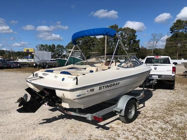 Slide: The Image of 2001 Stingray 180 LS/LX boat on trailer with blue canopy in sunny outdoor setting. - 4