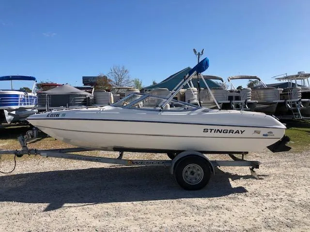 Slide: The Image of 2001 Stingray 180 LS/LX boat on trailer, parked outdoors under clear blue sky. - 6