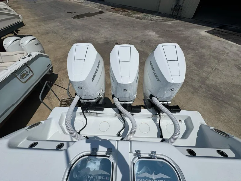 Slide: The Image of 2026 Invincible 43 Open Fisherman with triple Mercury outboard engines, docked on concrete. - 11