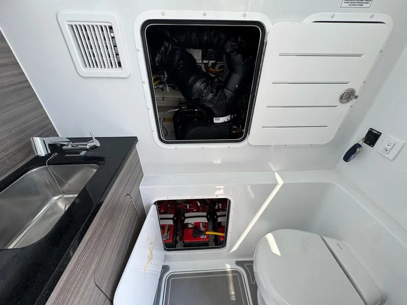 Slide: The Image of Interior of 2026 Invincible 43 Open Fisherman, featuring sink, toilet, and storage compartments. - 18