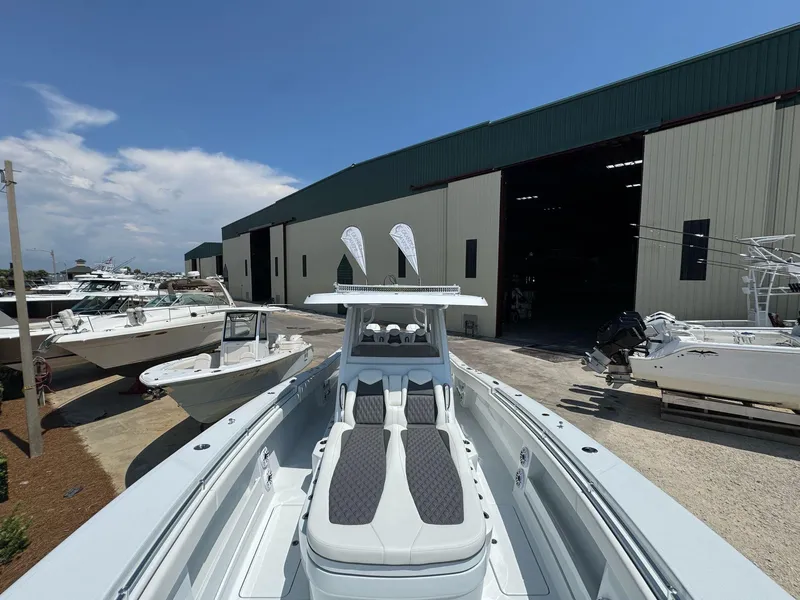 Slide: The Image of 2026 Invincible 43 Open Fisherman boat docked near a large warehouse. - 23