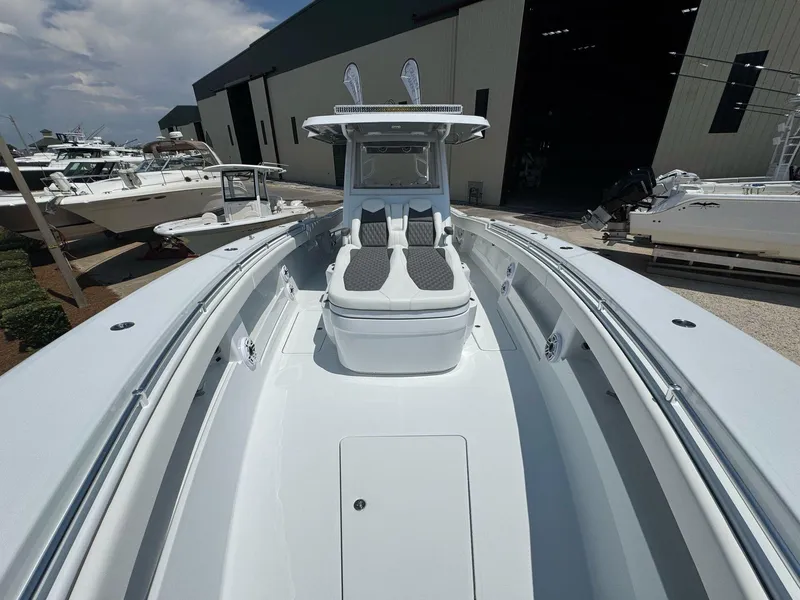 Slide: The Image of 2026 Invincible 43 Open Fisherman boat, sleek design, docked near a warehouse. - 28
