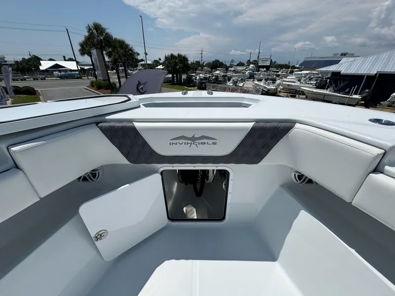 Slide: The Image of 2026 Invincible 43 Open Fisherman boat interior with storage compartment and logo. - 29