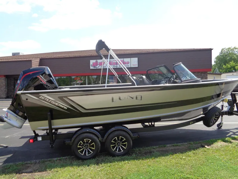 The Image of 2025 Lund 2075 Fisherman boat on trailer, parked outside a building. - 0