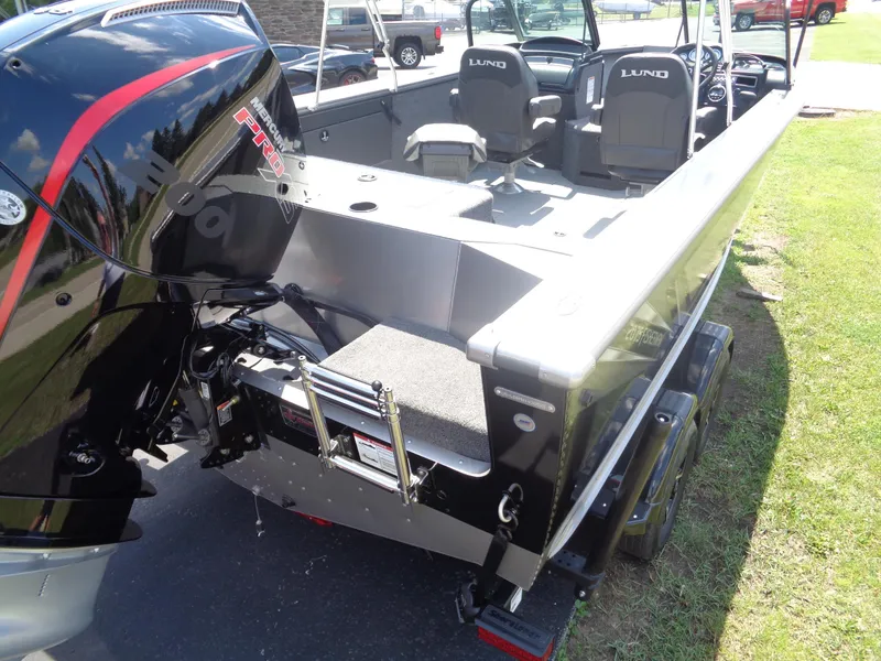 Slide: The Image of 2025 Lund 2075 Fisherman boat with Mercury Pro engine, parked on grass. - 11