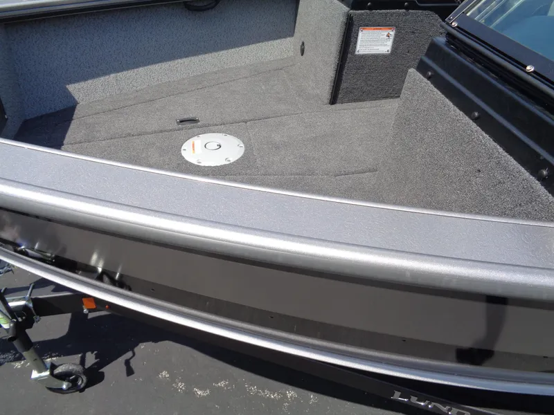 Slide: The Image of 2025 Lund 2075 Fisherman boat interior with carpeted deck and storage compartment. - 12