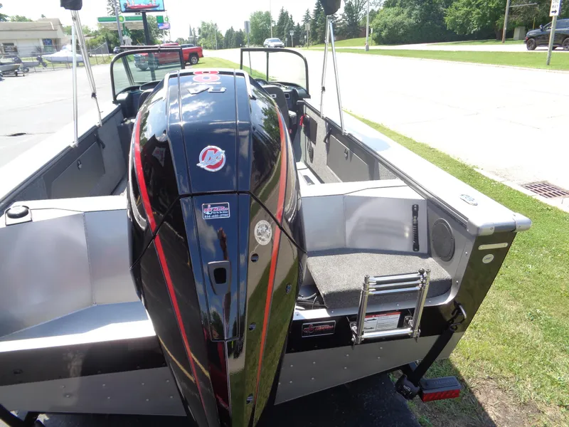 Slide: The Image of 2025 Lund 2075 Fisherman boat with powerful outboard motor, parked on grass. - 15