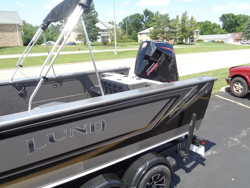 Slide: The Image of 2025 Lund 2075 Fisherman boat with Mercury Pro XS engine, parked outdoors. - 3