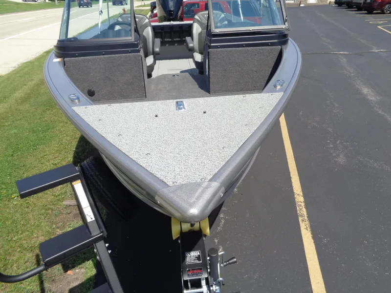 Slide: The Image of 2025 Lund 2075 Fisherman boat on trailer, parked on asphalt near grass. - 6