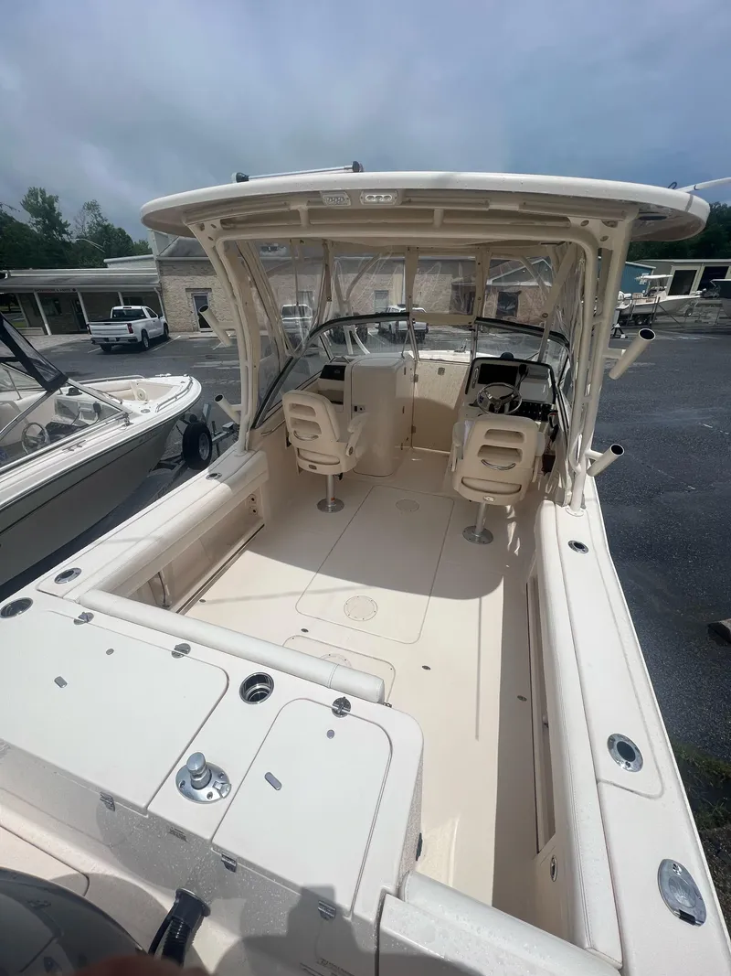 Slide: The Image of 2019 Grady-White Freedom 235 boat interior with seating and controls, parked outdoors. - 4