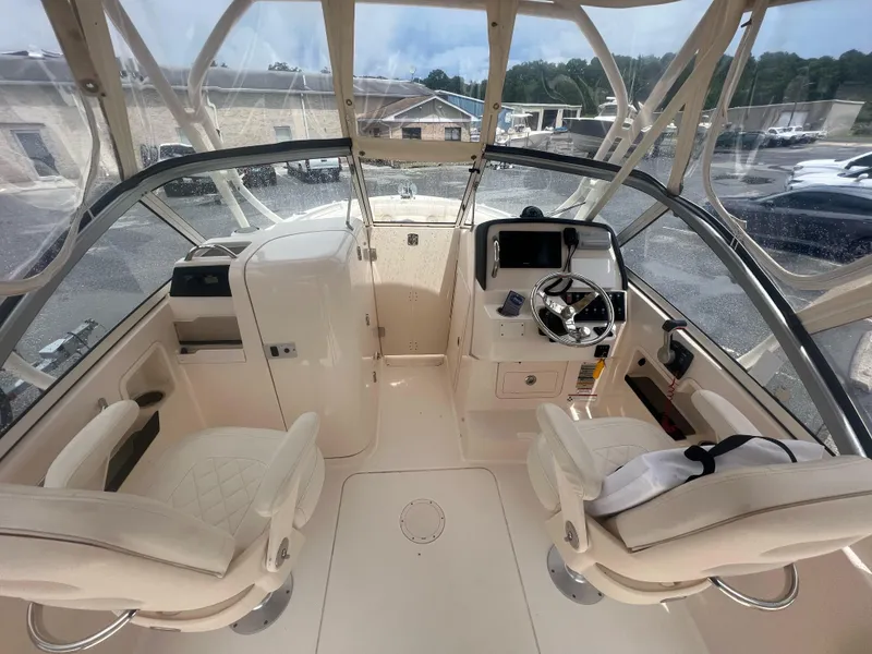 Slide: The Image of 2019 Grady-White Freedom 235 boat interior with helm, steering wheel, and seating. - 9
