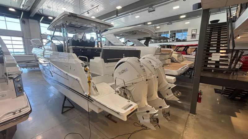 Slide: The Image of 2024 Jeanneau Leader 12.5 WA boat in showroom, featuring triple Yamaha outboard engines. - 3
