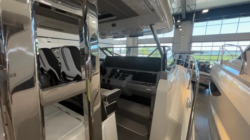 Slide: The Image of 2024 Jeanneau Leader 12.5 WA interior showcasing helm and seating area in a showroom. - 8