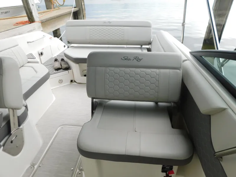 Slide: The Image of 2021 Sea Ray SDX 250 boat interior with gray seating and waterfront view. - 10