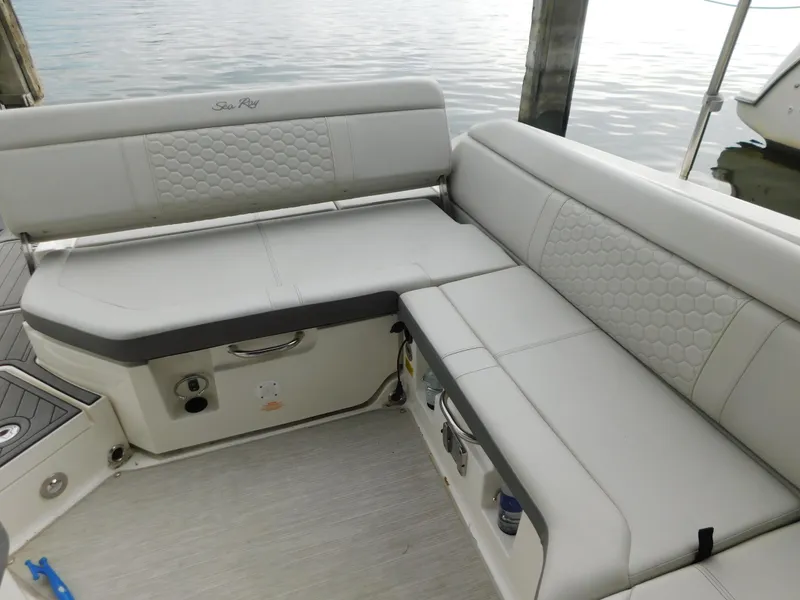 Slide: The Image of 2021 Sea Ray SDX 250 boat interior with cushioned seating by the water. - 17