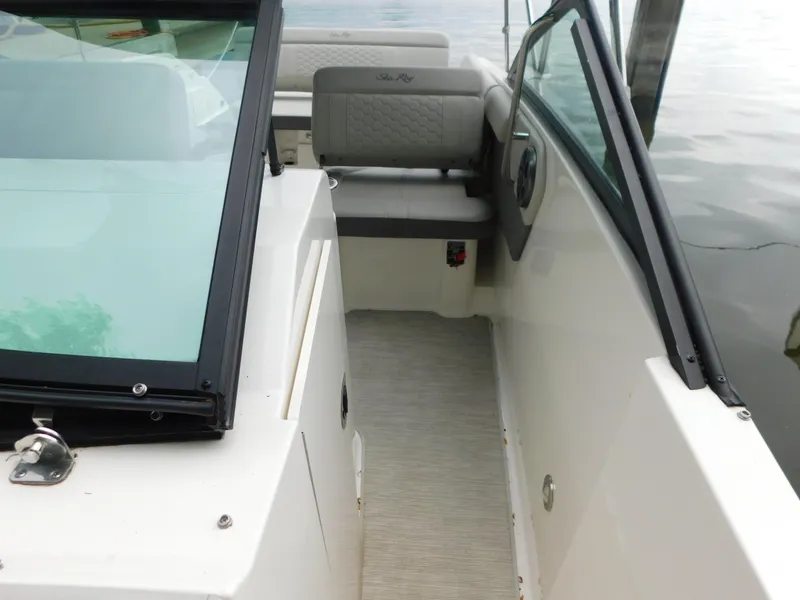 Slide: The Image of 2021 Sea Ray SDX 250 boat interior with seating and windshield, docked on calm water. - 7