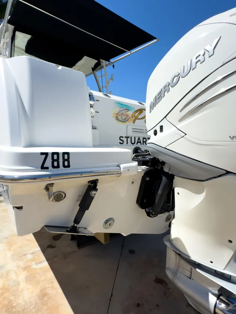 Slide: The Image of 2018 Boston Whaler 315 Conquest with Mercury engine, docked under clear blue sky. - 11