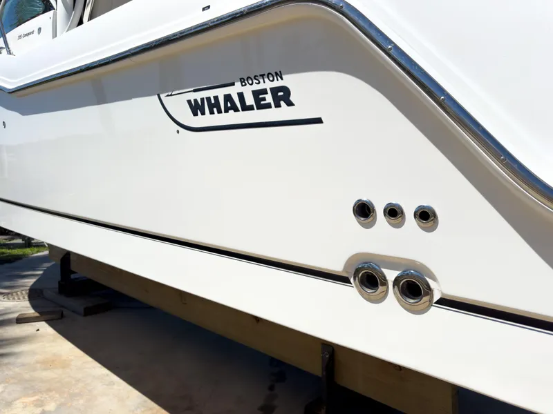 Slide: The Image of 2018 Boston Whaler 315 Conquest boat side view with logo and chrome fittings. - 13
