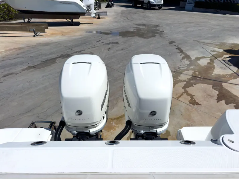 Slide: The Image of Twin outboard engines on a 2018 Boston Whaler 315 Conquest boat, parked on a concrete surface. - 15