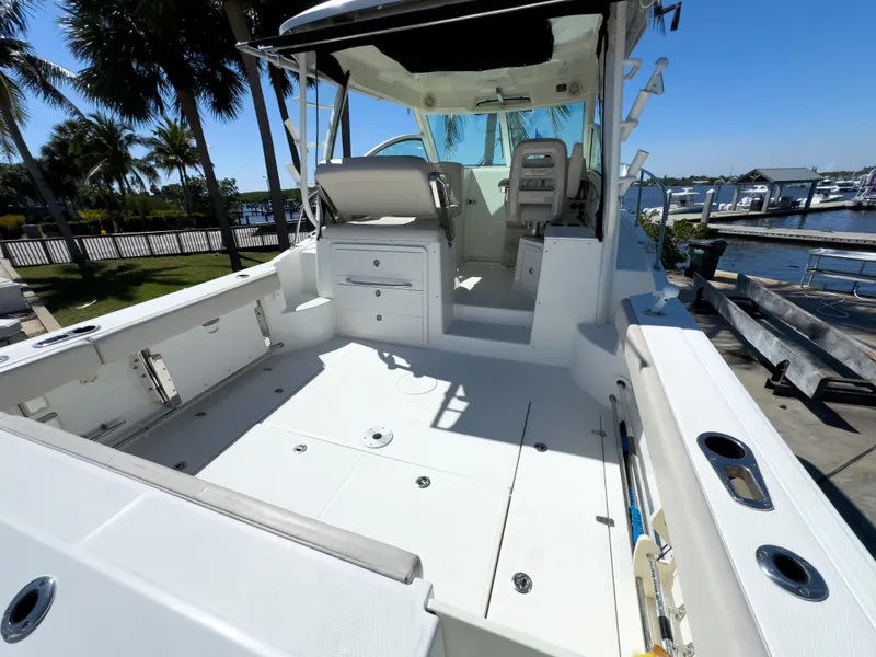 Slide: The Image of 2018 Boston Whaler 315 Conquest boat deck with seating, docked near marina. - 16