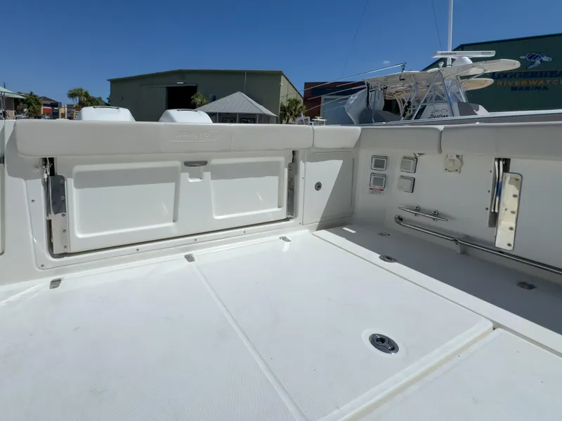Slide: The Image of 2018 Boston Whaler 315 Conquest boat deck, featuring storage compartments and clean design. - 18