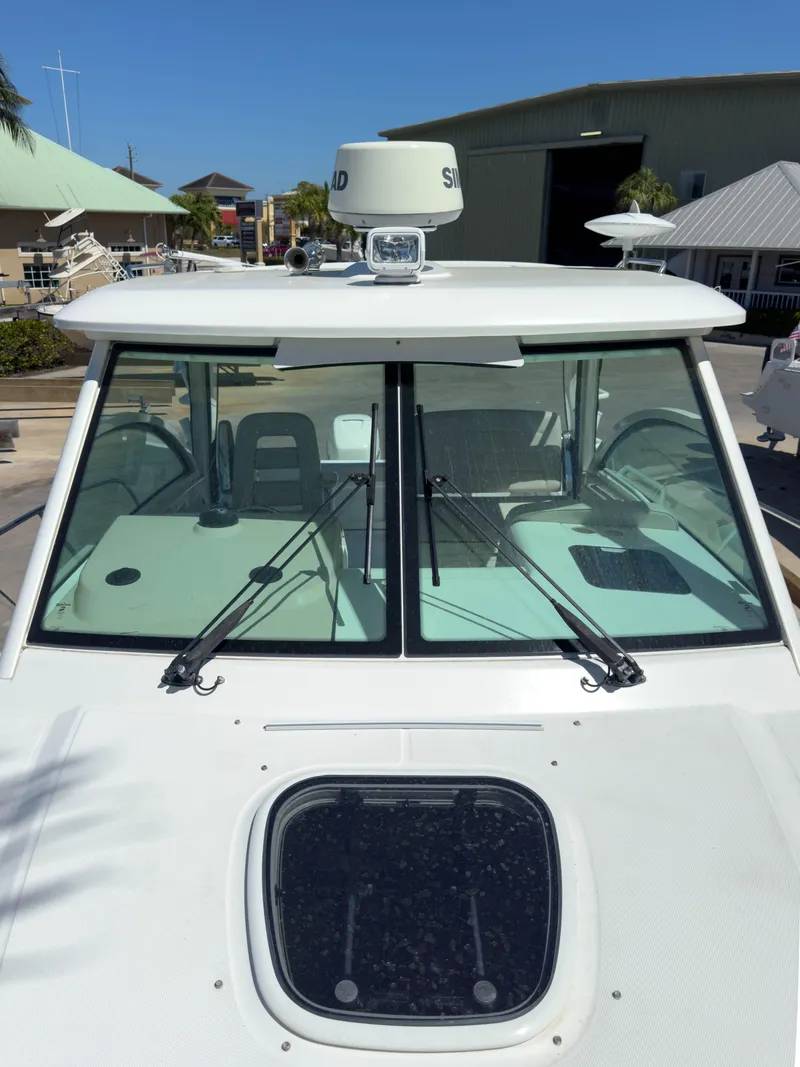 Slide: The Image of 2018 Boston Whaler 315 Conquest boat with radar, docked in a marina. - 42