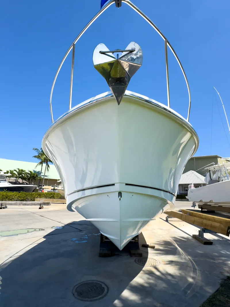 Slide: The Image of 2018 Boston Whaler 315 Conquest boat, front view, docked under clear blue sky. - 5