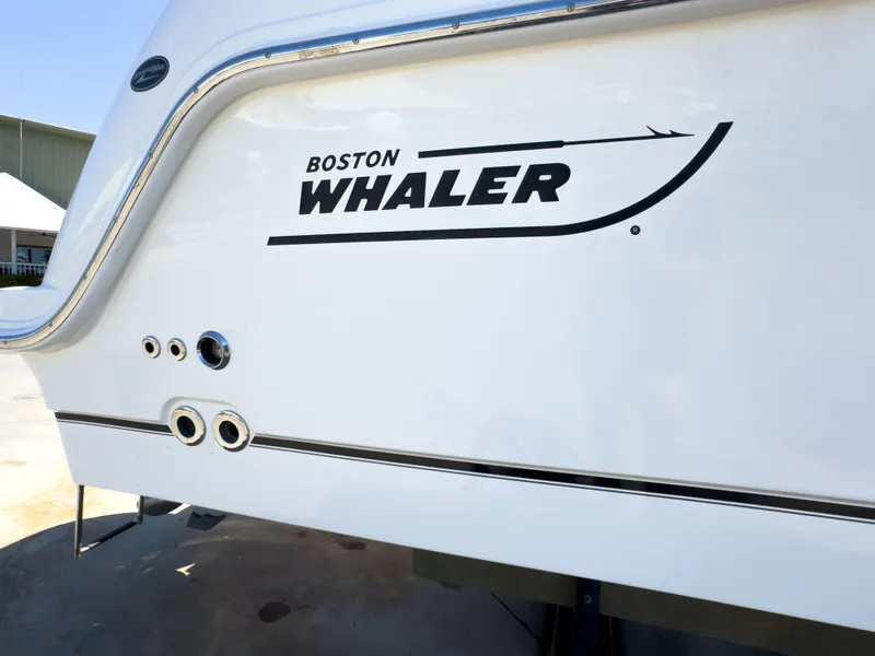 Slide: The Image of 2018 Boston Whaler 315 Conquest boat exterior with logo and sleek design. - 7