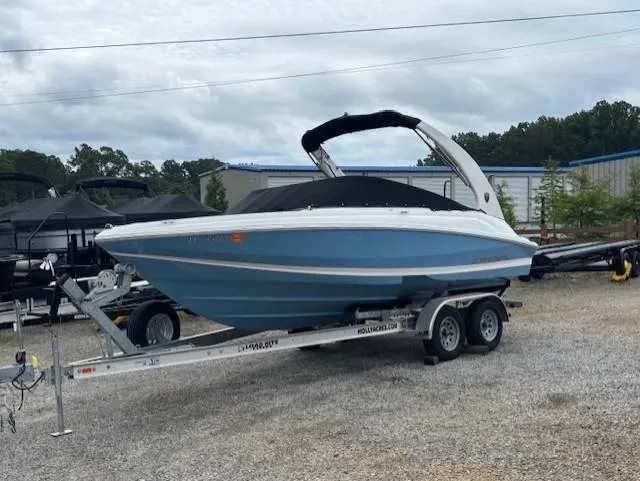 Slide: The Image of 2018 Regal 2000 ES Bowrider boat on trailer, blue and white, parked outdoors. - 2
