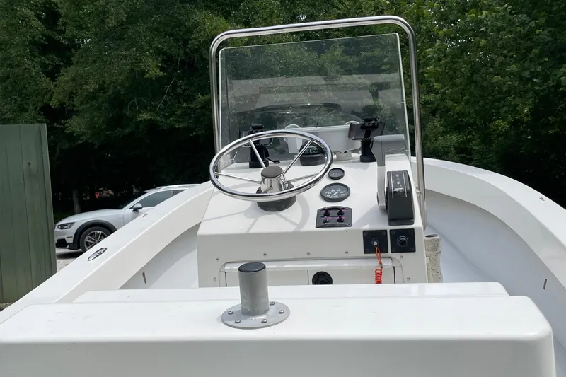 Slide: The Image of 2006 NorthCoast 180 Center Console boat with steering wheel and controls, surrounded by trees. - 3