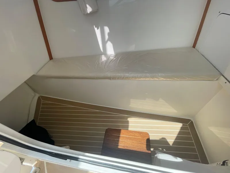 Slide: The Image of 2025 MJM 3 boat interior cabin with wooden flooring and cushioned seating. - 19