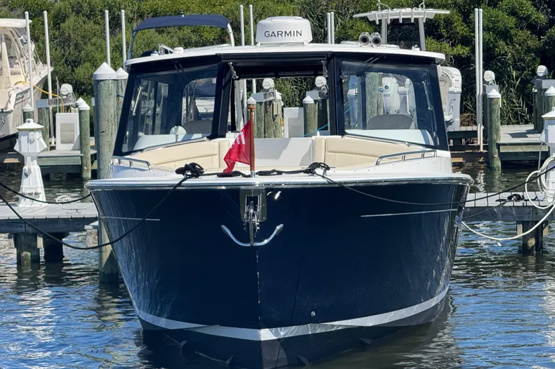 Slide: The Image of 2025 MJM 3 boat docked, featuring sleek design and Garmin navigation system. - 2