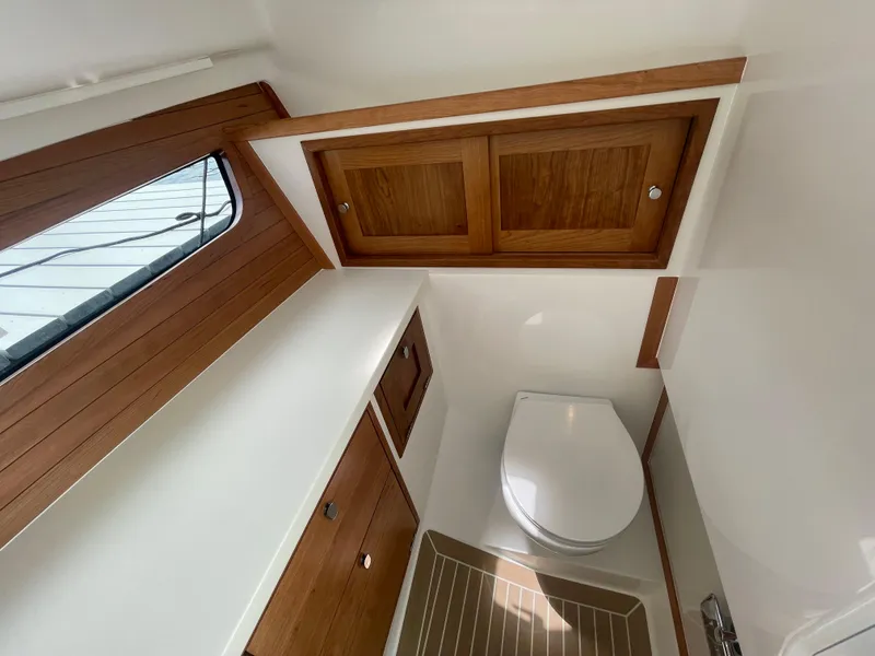 Slide: The Image of 2025 MJM 3 boat interior bathroom with wooden cabinets and window. - 23