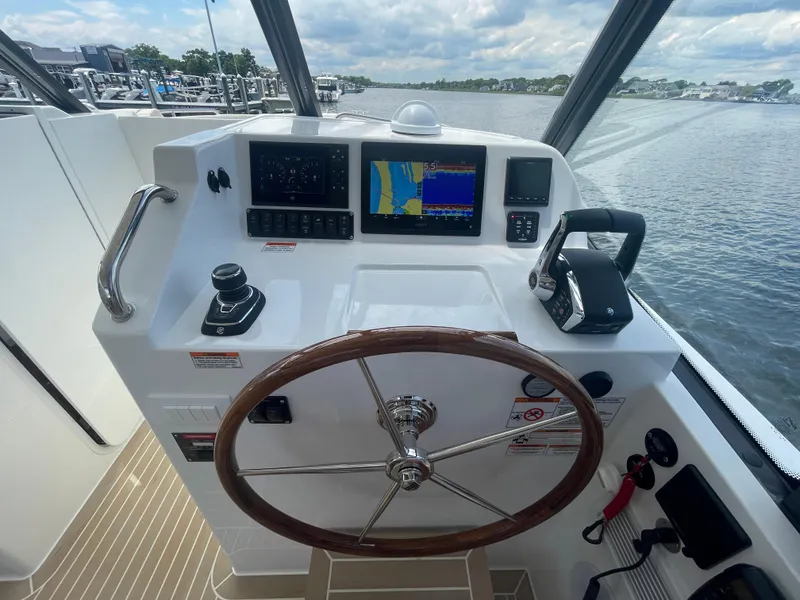 Slide: The Image of 2025 MJM 3 boat helm with navigation screens and steering wheel. - 24