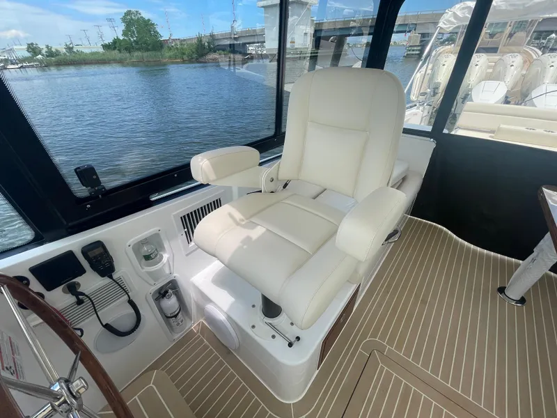Slide: The Image of Captain's chair in the 2025 MJM 3 boat cockpit, overlooking serene waters. - 28