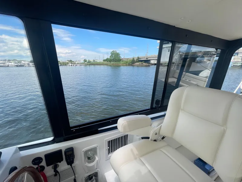 Slide: The Image of Interior view of 2025 MJM 3 boat with water and bridge in the background. - 29