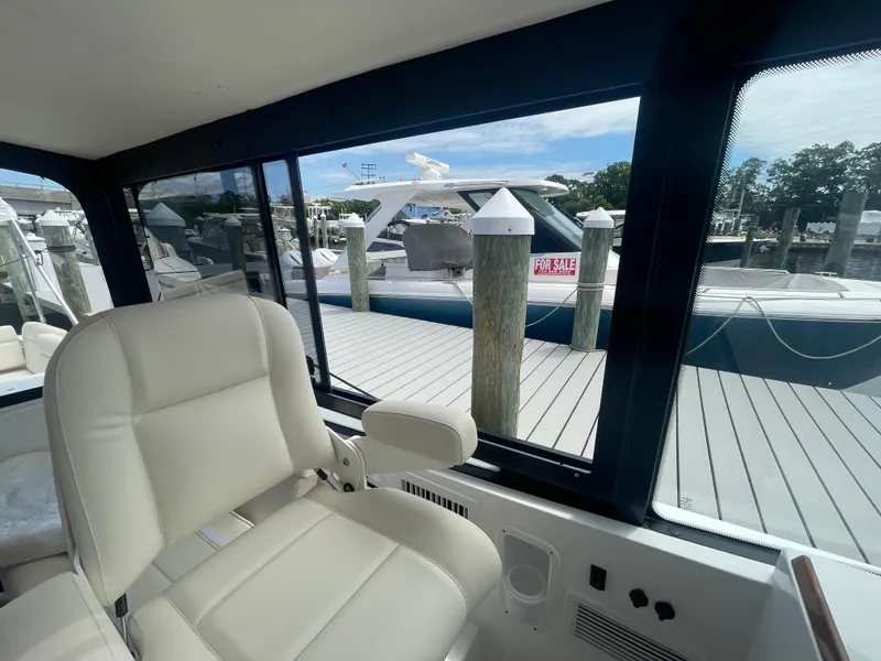 Slide: The Image of 2025 MJM 3 boat interior with white leather seat and marina view. - 31