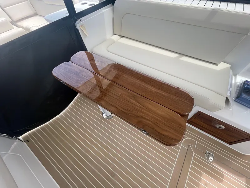 Slide: The Image of Interior of 2025 MJM 3 boat with wooden table and cushioned seating. - 37