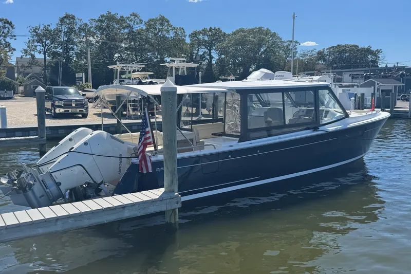 Slide: The Image of 2025 MJM 3 boat docked, featuring sleek design and dual outboard engines. - 5