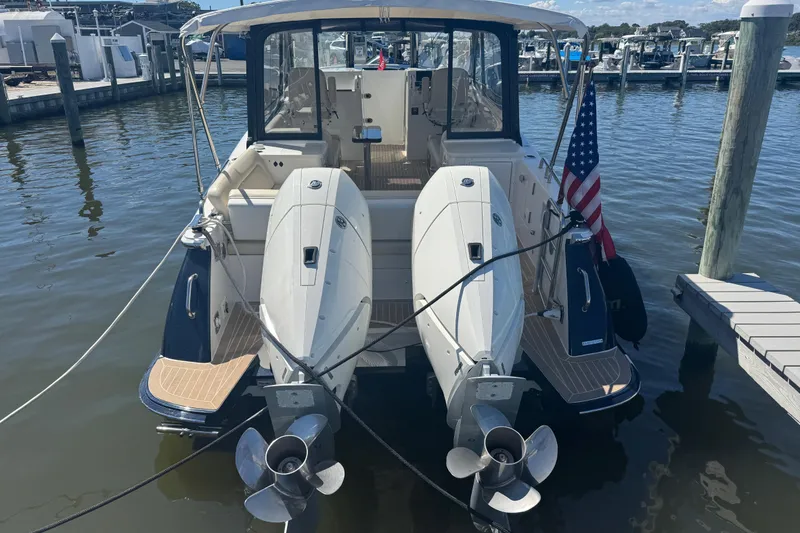 Slide: The Image of 2025 MJM 3 boat docked with dual outboard motors and American flag. - 7
