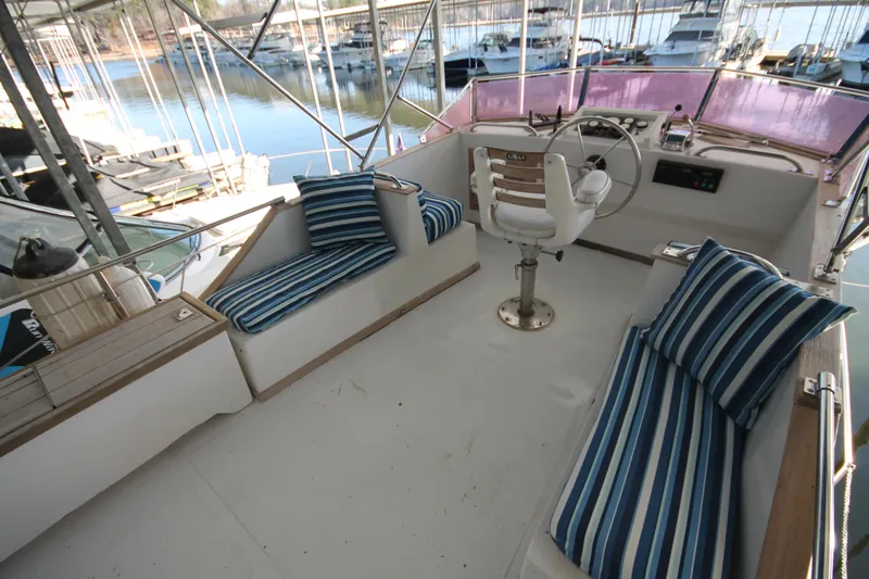 Slide: The Image of 1986 Senator 35 Sundeck Trawler interior with striped cushions and steering wheel. - 14